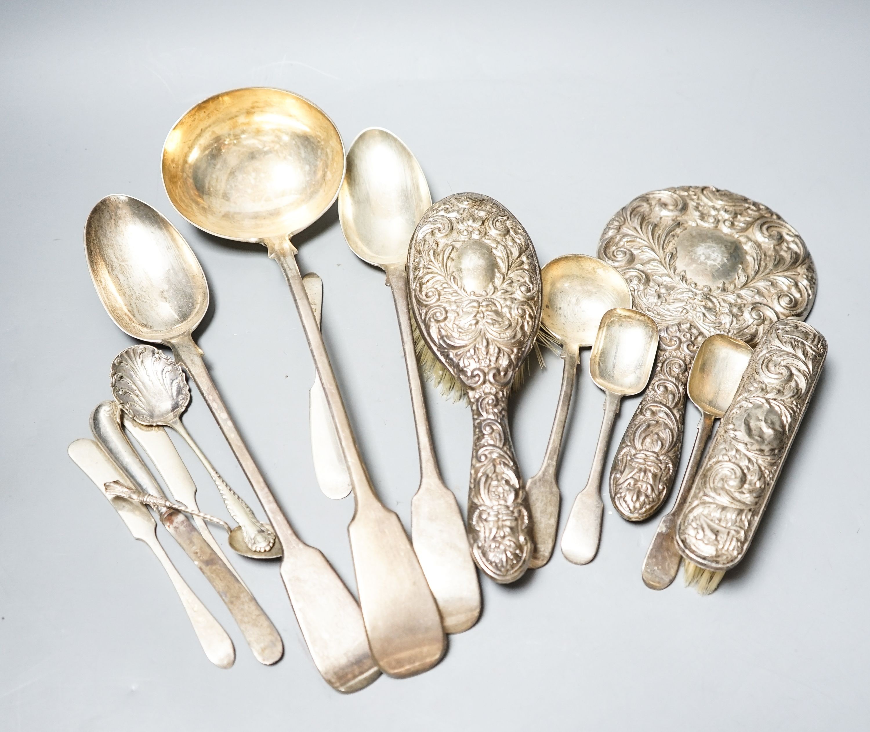 A group of silver flatware including a Victorian soup ladle and two basting spoons and three dressing table accessories, weighable silver 24oz